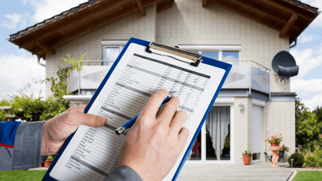 Person holding a clipboard with a checklist in front of a house
